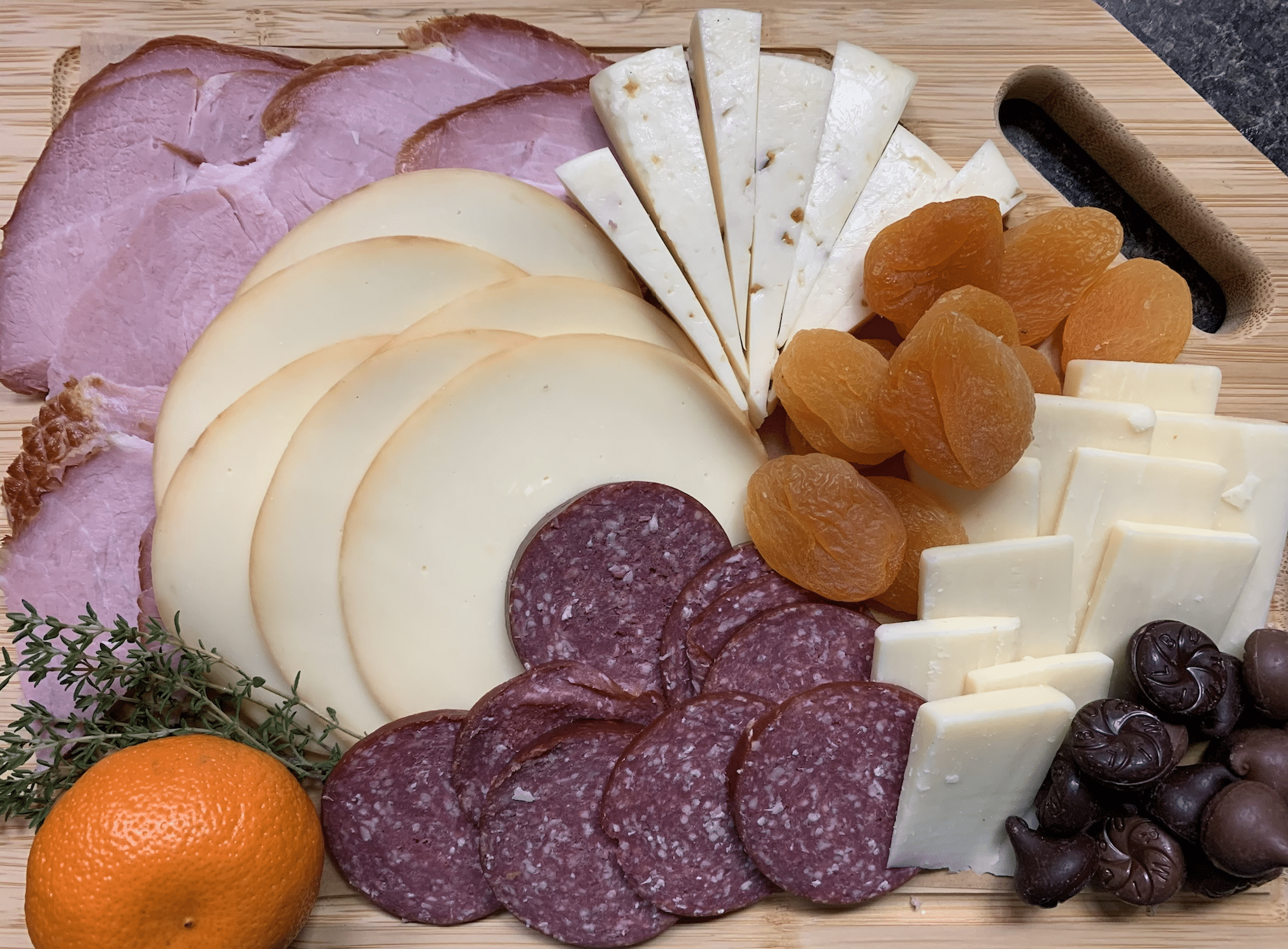 Charcuterie board filled with delicious dried meats, cheeses fruits, chocolates and more.