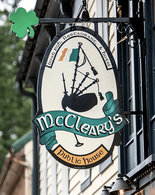 Oval wooden sign with bagpipes and the name McCleary's.
