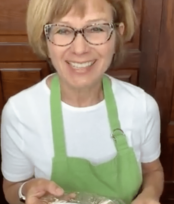 Olde Square Inn Innkeeper with a green apron holding a piece of strudel