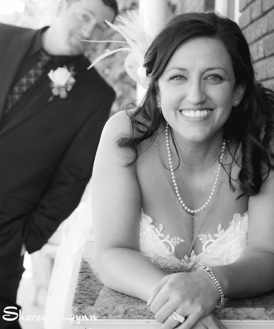 Black and white photo bride on a dresser groom in the background
