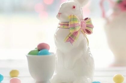 white ceramic bunny next to an egg cup with pastel jelly beans