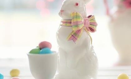 white ceramic bunny next to an egg cup with pastel jelly beans